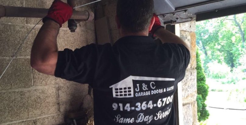 J&C Garage Doors technician repairing a garage door in Westchester, NY